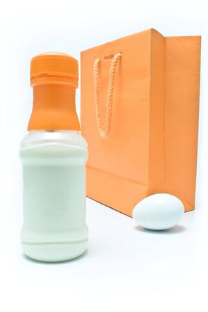 Bottle of milk,egg and shopping bag on white backgroundの写真素材