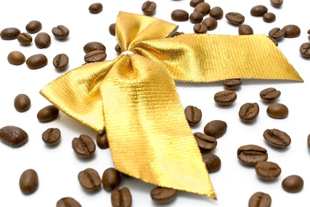 Coffee beans with golden gift bow on whiteの写真素材
