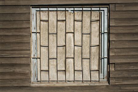 Old wooden wall with boarded up window as backgroundの写真素材