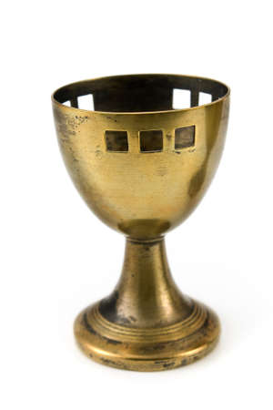 Old brass egg cup isolated on whiteの写真素材