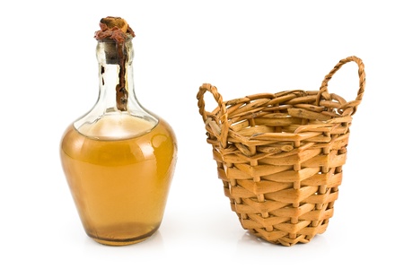 Old sealed bottle of white wine with basket isolated on whiteの写真素材