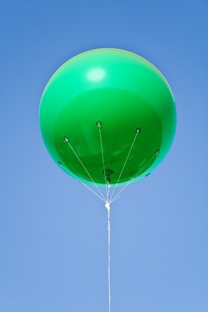 Green big balloon over blue skyの写真素材