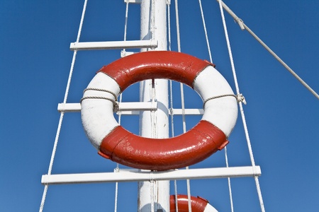 Life buoy and sailing mast over blue skyの写真素材