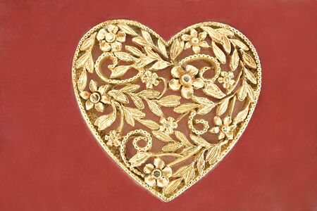 Golden heart jewelry  on red backgroundの写真素材