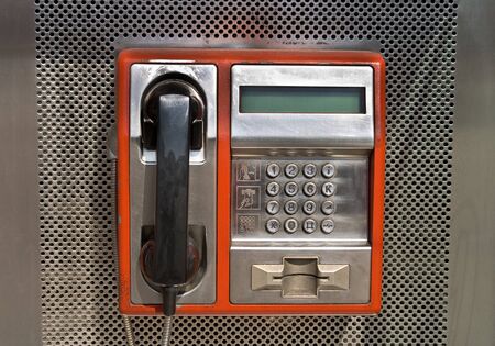 Orange public telephone on metallic backgroundの写真素材