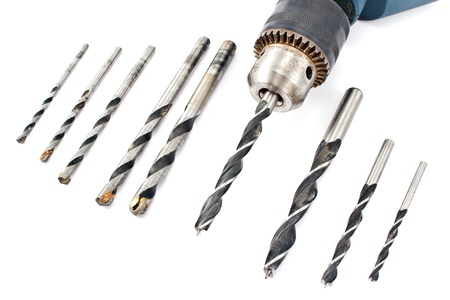 Drill and set of wood drill bits isolated in white