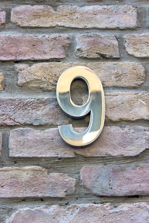 House number 9 zinc plate on brick wallの写真素材