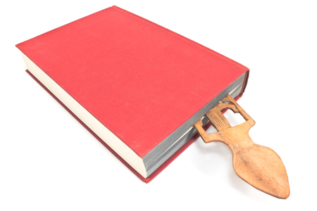 Wooden bookmark in a book isolated on whiteの写真素材