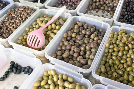 Bowls of various olives for sale at a marketの写真素材