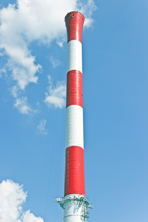Industrial red and white chimney over blue skyの写真素材