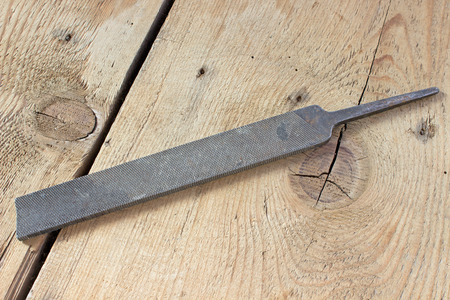 Old rusty rasp on wooden backgroundの写真素材