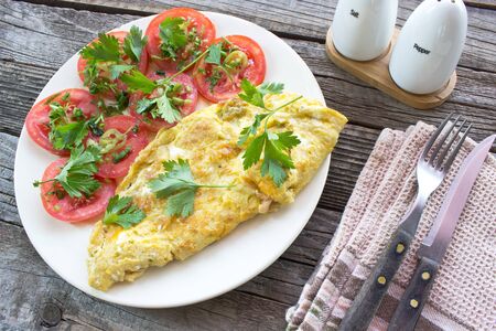 Omelette fried eggs with vegetables on wooden backgroundの写真素材