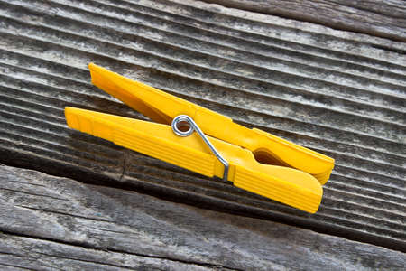 Yellow Clothespin on wooden backgroundの写真素材