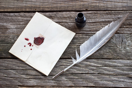 Wax sealed letter with quill on wooden backgroundの写真素材