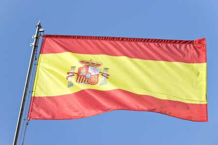 Spanish flag over blue skyの写真素材