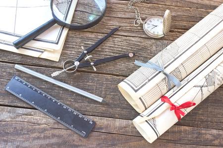 Old Maps with tools on wooden background