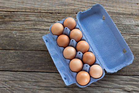 Eggs in a cardboard package on wooden background