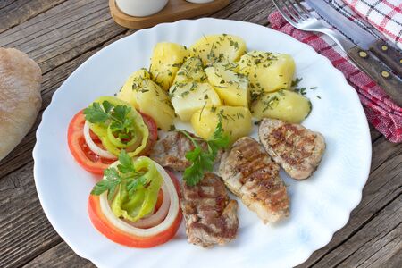 Grilled pork fillet meat and vegetables on plateの写真素材