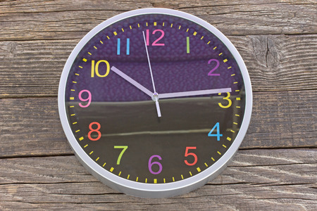 Wall clock on old wooden background