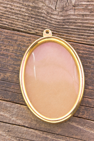 Golden oval frame on wooden backgroundの写真素材