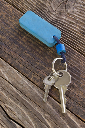 Keys with blue tag on wooden backgroundの写真素材