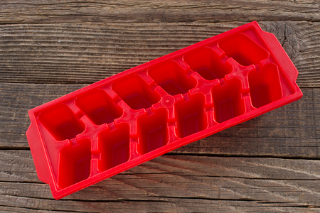 Plastic ice container on wooden backgroundの写真素材