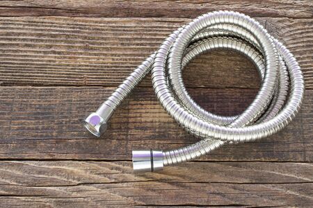Water hose for shower on wooden backgroundの写真素材