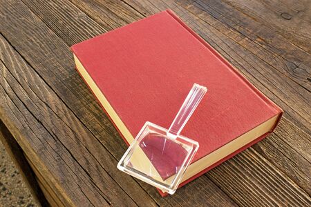 Magnifying glass with book on wooden tableの写真素材