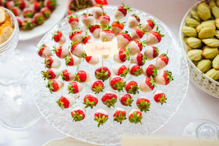 Strawberries with white chocolate on the plate in candy bar