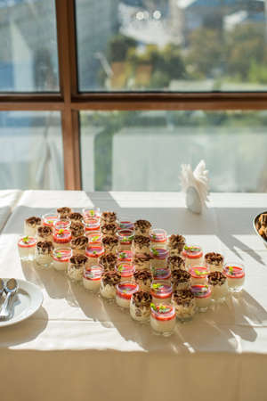 Sweet mousses with chocolate and strawberries with mint near the window on the table