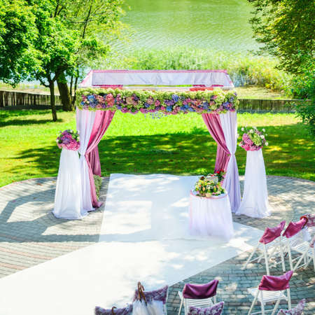 beautiful arch decorated with colorful flowers on wedding ceremony outdoorsの写真素材