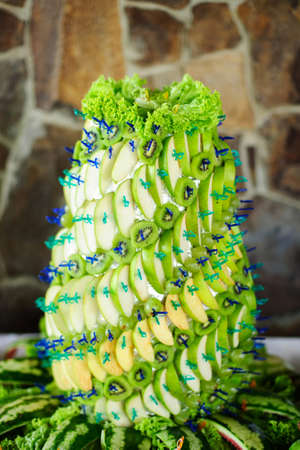 Sweet pyramid with apples, kiwi and grapes for wedding or event banquet