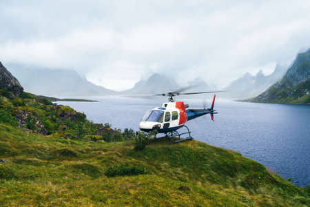 Helicopter in the great Norway mountains in cloudy weather. Reine, Lofotensの写真素材