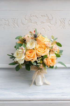 Beauty of yellow flowers. Bridal accessories. Close-up bunch of florets. Details for marriage and for married couple. Wedding bouquet with yellow roses and ribbonsの写真素材