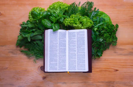 Composition with salad and bible on wooden backgroundの写真素材