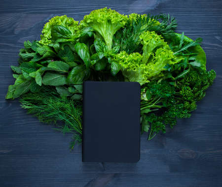 Composition with salad and bible on wooden backgroundの写真素材