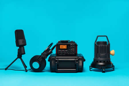 Equipment for field audio recording on blue background. recorder, headphones, usb mic, lamp and case.の写真素材