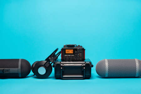 equipment for field audio recording on blue background. Windshield, recorder, portable case and headphonesの写真素材