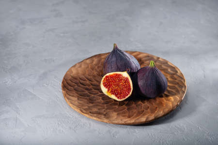A few figs on a plate on an grey background. Healing Fruit
