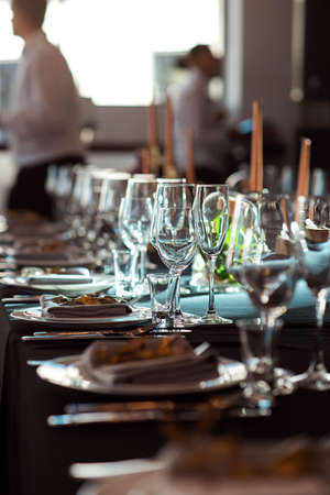 Sparkling glassware stands on table prepared for wedding. Wedding decor, interior. Festive. Banquet table.の写真素材