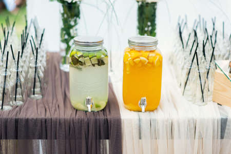 Glass jars of lemonade on wedding candy bar. Catering. Drinks on wedding partyの写真素材