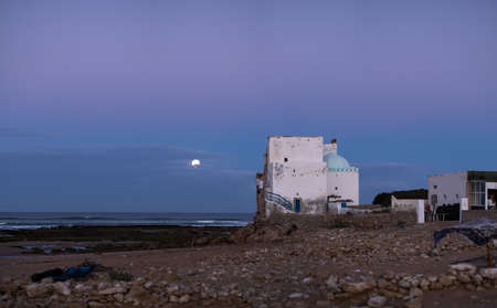 Old building at coast of Sidi Kaouki, Morocco, Africa. Moon in the evening sky.  Sunset time. morocco's wonderfully sleepy surf townの写真素材