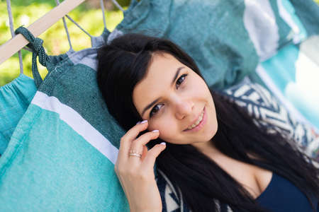 Young beatifull girl in hammock enjoying sunny weekend somewhere in green spring woodの写真素材