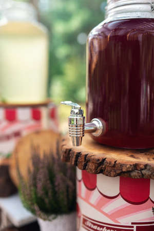 Glass jars of lemonade on wedding candy bar. Catering. Drinks on wedding party. Summer wedding in the forest の写真素材