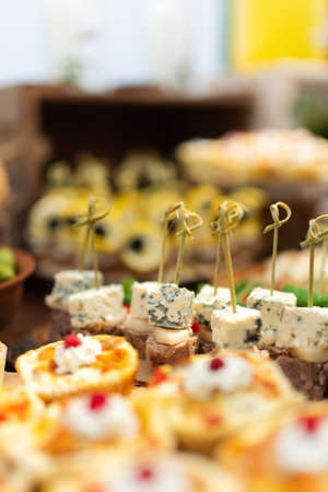 Tasty meals on a brown rustic wooden banquet table. Summer wedding in the forest