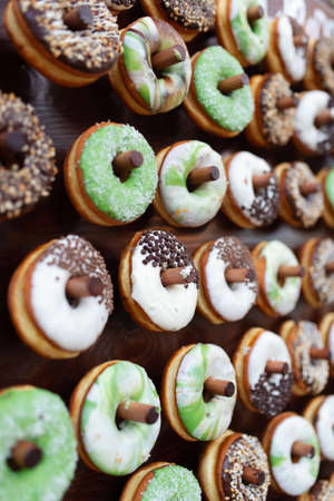 Delicious donuts on wooden stander. Wedding in the forest. Wedding decor. Donuts for guestsの写真素材