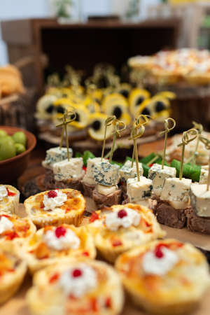Tasty meals on a brown rustic wooden banquet table. Summer wedding in the forestの写真素材