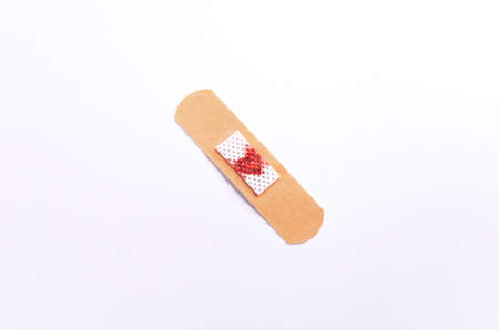 Medical bandage  with a red heart on it, on a white background. Flat lay.の写真素材