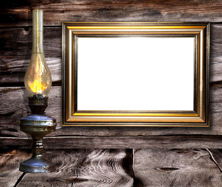Old rusty lamp against  and decorative retro frames for a photo dark wooden boardsの写真素材