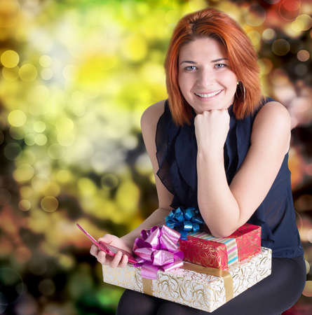 Happy smiling red-haired woman with boxes gifts Holiday conceptの写真素材